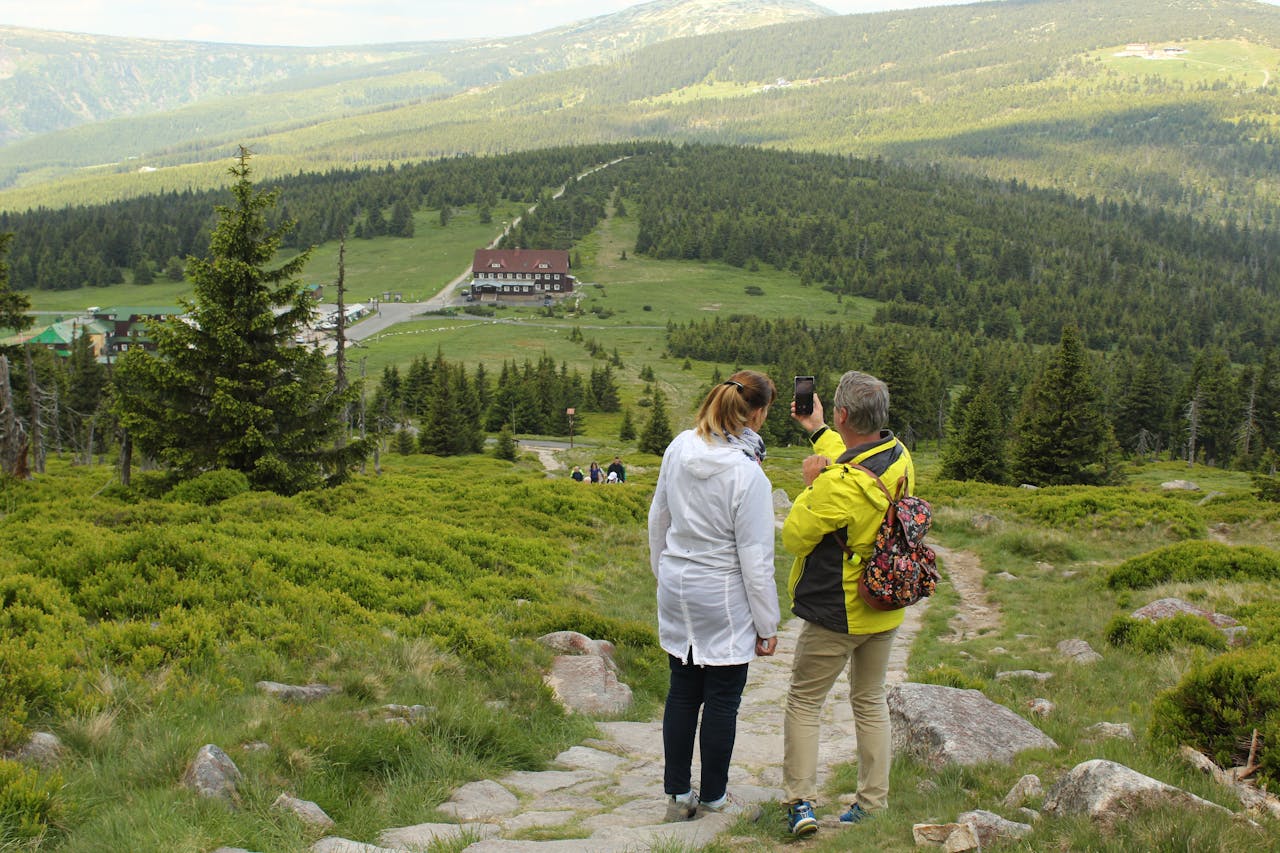 Couple hiking and capturing scenic views in Jelenia Góra, Poland.